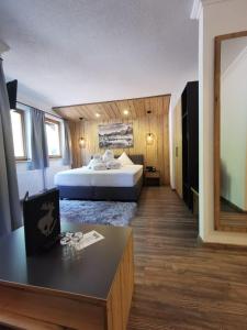 a hotel room with a bed and a table at Hotel Möderle in Sankt Leonhard im Pitztal