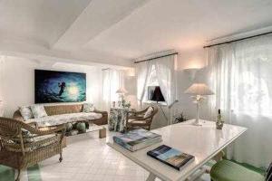 een woonkamer met een bank en een tafel bij GOCCE VILLAS - Green Coral Villa di lusso 1950 in Capri