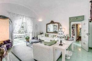 een woonkamer met een bank en een tafel bij GOCCE VILLAS - Green Coral Villa di lusso 1950 in Capri