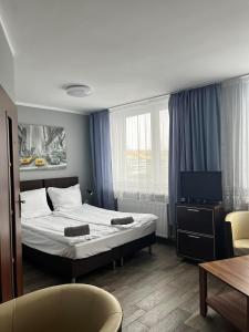 a hotel room with a bed and a television at AtmosferA in Bydgoszcz