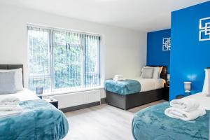 a bedroom with two beds and a blue wall at Executive 8beds 3bath Contractors Welcome Parking in Southampton