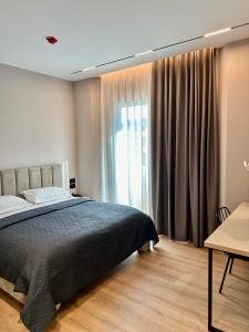 a bedroom with a bed and a large window at Venis Hotel in Tirana