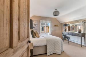 a bedroom with a bed and a desk at Marsh Mallow Cottage - Hot Tub Packages Available in Loughborough