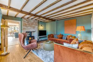 sala de estar con sofá, sillas y chimenea en Marsh Mallow Cottage - Hot Tub Packages Available, en Loughborough