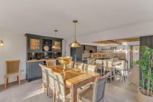 een keuken en eetkamer met een houten tafel en stoelen bij Marsh Mallow Cottage - Hot Tub Packages Available in Loughborough