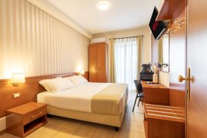 Pokój hotelowy z łóżkiem i biurkiem w obiekcie AlbaDomus Affittacamere o GuestHouse w Rzymie