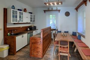 a kitchen with a wooden table and a dining room at Chalupa EMA in Abertamy