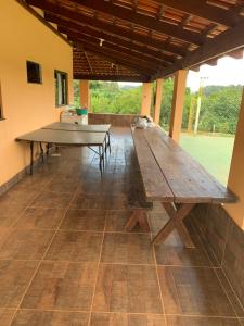 uma grande mesa de piquenique em madeira num pátio em Rancho próximo ao lago de furnas em Boa Esperança