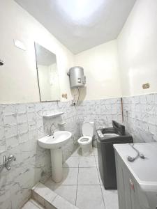 a white bathroom with a sink and a toilet at Cozy room in the heart of cairo in Cairo