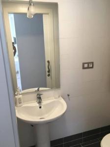 un baño con lavabo y espejo en ATICO MORAIRA, en Moraira 19 fotos más