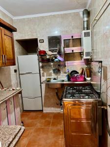 uma pequena cozinha com um fogão e um frigorífico em Cozy room in the heart of cairo no Cairo