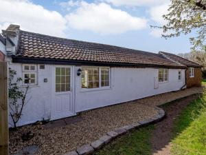 a white house with a door and a yard at 1 bed in Wroxham 87414 in Hainford