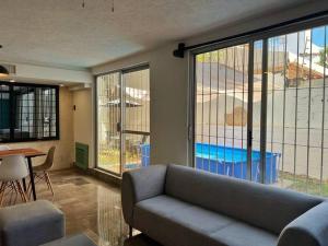 a living room with a couch and large windows at Espacioso, Centrico, Acogedor y Buena Ubicacion in Cancún