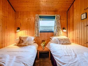 two beds in a room with a window at 3 Bed in Ullswater 88212 in Tirril