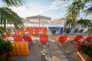 un grupo de sillas y mesas en la playa en Panorama Hotel en Paralia Katerinis