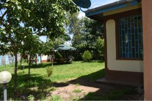 uma casa com um quintal com uma mesa e um guarda-chuva em D'LUX HOME RODI KOPANY em Homa Bay