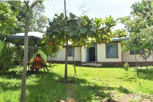 een persoon die op een tafel voor een huis zit bij D'LUX HOME RODI KOPANY in Homa Bay