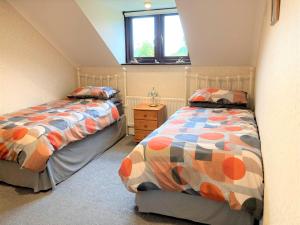 a bedroom with two beds and a window at 3 Bed in Greystoke 89268 in Newton Reigny