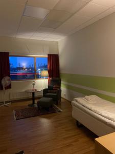 Zimmer mit einem Bett, einem Stuhl und einem Tisch in der Unterkunft Trestads Värdshus in Vänersborg