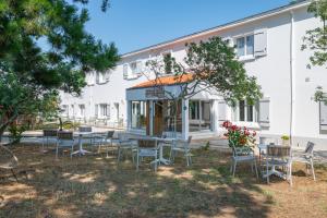 a group of chairs and tables in front of a building at Hotel Esperanza in Noirmoutier-en-l'lle