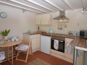 a kitchen with white cabinets and a table and a counter at 1 Bed in Torrington 42982 in Petrockstow