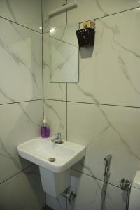 Arabian Holiday Resort Family Cottage One Room Two Bed في ادوكي: حمام أبيض مع حوض ومرآة