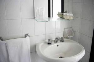 bagno bianco con lavandino e specchio di Hotel Laura Beach a Rimini