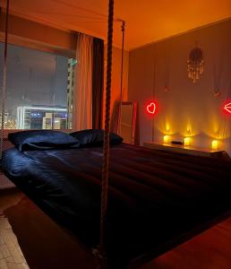 a bedroom with a canopy bed with a view of a city at Skanstes Virsotnes Flying Bed Apartment (Skanstes Heights) in Riga