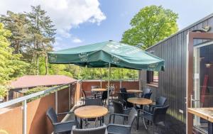 eine Terrasse mit Tischen, Stühlen und einem Sonnenschirm in der Unterkunft Groepsaccommodatie / Familiehuis Bolle Buik, Borrel & Bed Appelscha in Appelscha