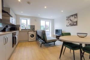 a kitchen and living room with a table and a table and chairs at All Inn Apartments in Staveley