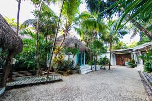 una casa con palmeras delante en Hotel Cormoran Tulum & Cenote en Tulum