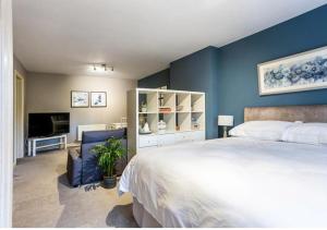 a bedroom with a white bed and a blue wall at The Studio @ No. 6 in Brimscombe