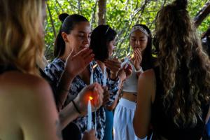 Un groupe de femmes debout autour de bougies d'éclairage dans l'établissement Hotel Cormoran Tulum & Cenote, à Tulum