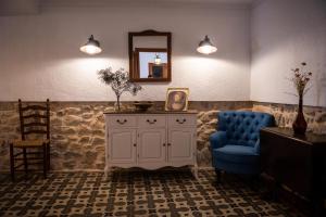 uma sala de estar com uma cadeira azul e um espelho em CASA LOLA Naturaleza, Montañas y Piscina Compartida De Pueblo em Carroja