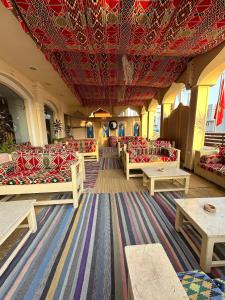 Elaria Hotel Hurgada في الغردقة: غرفة بها كنب وطاولات وسقف احمر