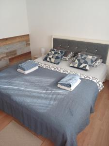 ein Schlafzimmer mit einem großen Bett mit blauer Bettwäsche und Kissen in der Unterkunft Sobe sa kupatilom Jajce in Jajce