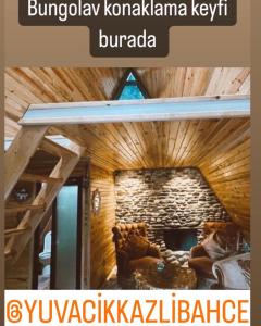 a room with a stone wall with a couch in front at yuvacik kazli bahçe bungalov otel ve restoran in Yuvacık