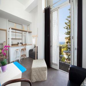 ein Wohnzimmer mit Blick auf einen Balkon in der Unterkunft Agora Apartments in Sorrent