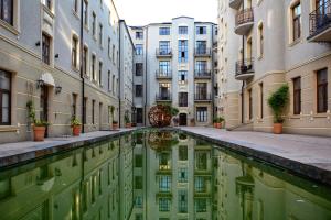 a courtyard of a building with a pool of water at West Side Piotrkowska Apartment in Łódź