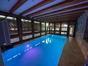 una gran piscina con iluminación azul en una casa en Auszeit im Wald - mit Schwimmbad!, 