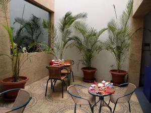 ein Zimmer mit Tischen, Stühlen und Topfpflanzen in der Unterkunft DON ALEJANDRO in Trujillo