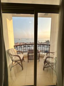 balkon z krzesłami i widokiem na ocean w obiekcie Elaria Hotel Hurgada w mieście Hurghada