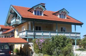 ein Haus mit einem orangenen Dach und einem Balkon in der Unterkunft Ferienwohnung Bernau in Bernau am Chiemsee
