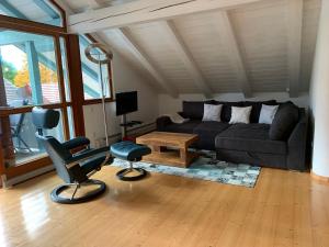 ein Wohnzimmer mit einem Sofa und einem Stuhl in der Unterkunft Ferienwohnung Bernau in Bernau am Chiemsee