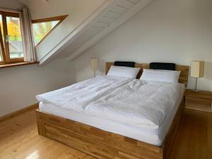 ein Schlafzimmer mit einem großen Bett mit weißer Bettwäsche in der Unterkunft Ferienwohnung Bernau in Bernau am Chiemsee