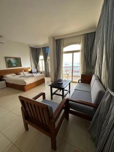 een hotelkamer met 2 bedden en een bank bij Elaria Hotel Hurgada in Hurghada