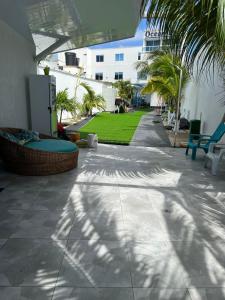 a patio with a lawn with palm trees and a building at APARTAMENTO FAMILIAR EN HOTEL in San Andrés