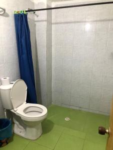 a bathroom with a toilet and a blue shower curtain at Posada Casamar 2 in San Andrés