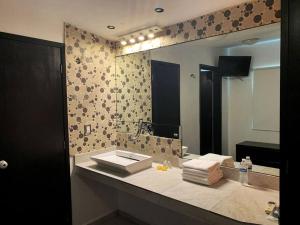 La salle de bains est pourvue d'un lavabo et d'un grand miroir. dans l'établissement Espaciosa,Centrica y bonita casa, 10 personas, à Cancún