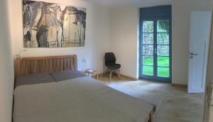 Schlafzimmer mit einem Bett mit Wandgemälde in der Unterkunft Prima Klima Villa - Ferienwohnung Steinbrecher in Struppen
